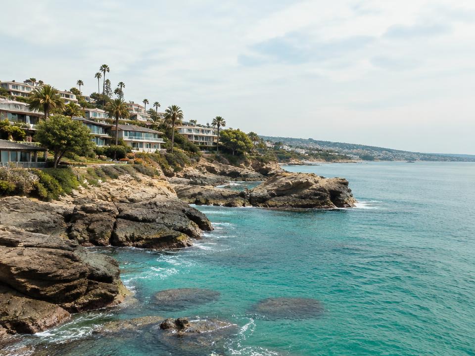 Rocky Laguna Beach cove with clear water and hillside homes